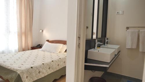 a bathroom with a bed and a sink in a room at Radama Hotel in Antananarivo