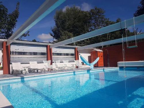 een zwembad met stoelen en een waterglijbaan bij Vakantievilla - Valkenisseweg 68 - Biggekerke 'Strand Villa' in Biggekerke