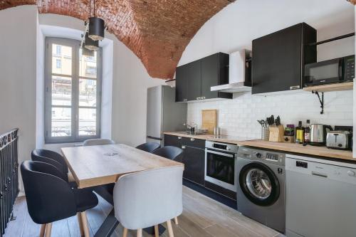 - une cuisine avec une table et un lave-linge/sèche-linge dans l'établissement Superbe Appartement Au Coeur du Vieux Nice !, à Nice