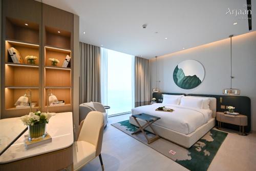 a hotel room with a bed and a desk and a table at Onyx Rotana in Manama