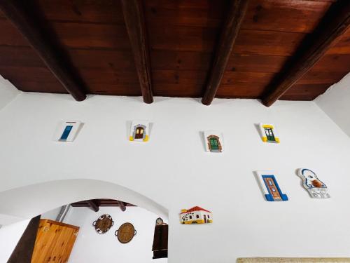 a room with white walls and wooden ceilings with different objects on the wall at É um Descanso in Campinho
