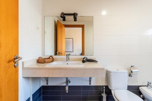 a bathroom with a sink and a toilet and a mirror at AB Sagrada Familia - Sant Pau in Barcelona