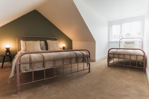 a bedroom with two beds in a attic at Feature Stone, Stunning Apartment, 2 x King Beds and Single, Sleeps 5 in Castle Cary