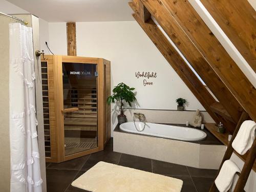 a bathroom with a bath tub and a sink at Der Moserhof in Oberaurach