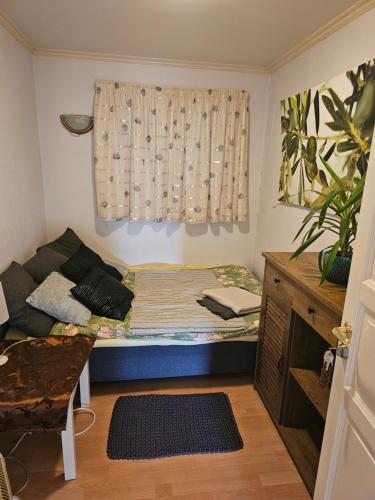 um pequeno quarto com uma cama e uma janela em Guesthouse Karmøy em Sæveland