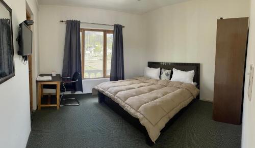 a bedroom with a large bed and a window at YANG-LHA GUEST HOUSE in Leh