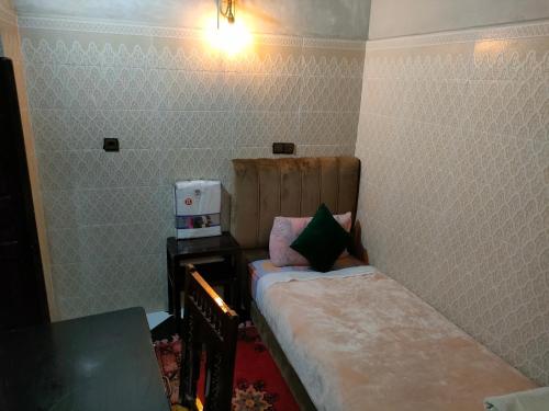 Cette petite chambre comprend un lit et une table. dans l'établissement RIAD Tamazouzt, à Essaouira