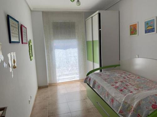 a small bedroom with a bed and a window at Extraordinario ático de 80 m2 en urbaniz privada in Noja