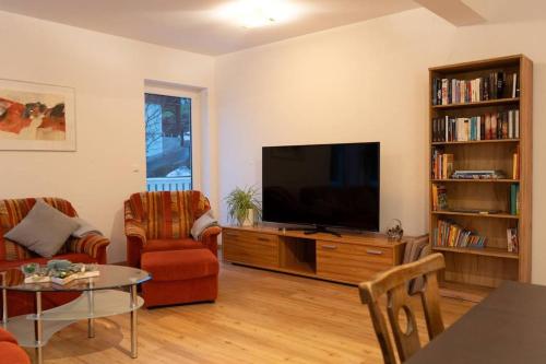 sala de estar con TV de pantalla plana en un centro de entretenimiento en Tanjas gemütliches Haus am Mondsee en Innerschwand