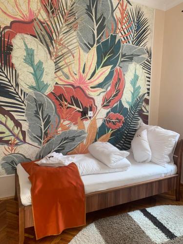 a couch in a room with a floral wall at Szent István Apartman in Makó