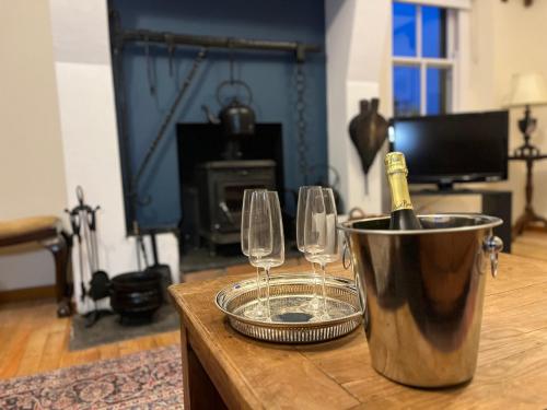 a bucket with a bottle of champagne and two wine glasses at Dunnaglea Cottage, Ballintoy in Ballintoy