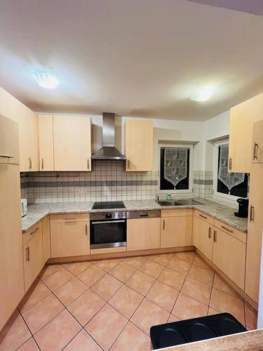 a kitchen with wooden cabinets and a stove top oven at Tanjas gemütliches Haus am Mondsee in Innerschwand am Mondsee