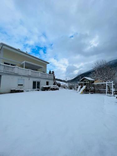a house with snow on the ground in front of it at Tanjas gemütliches Haus am Mondsee in Innerschwand am Mondsee