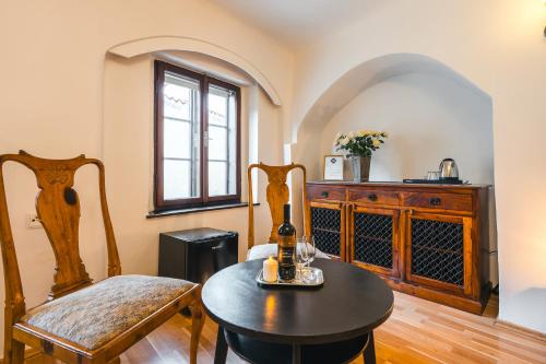 a room with a table and a chair and a bottle of wine at Penzion U náměstí - At the Town Square in Český Krumlov