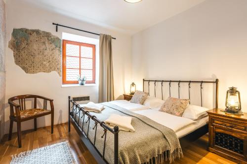 a bedroom with a bed and a chair at Penzion U náměstí - At the Town Square in Český Krumlov