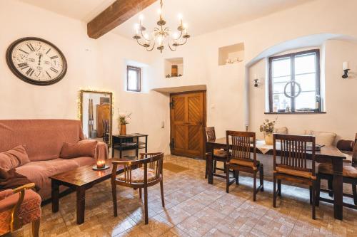 a living room with a couch and a clock on the wall at Penzion U náměstí - At the Town Square in Český Krumlov