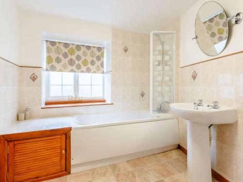 La salle de bains est pourvue d'une baignoire et d'un lavabo. dans l'établissement 3 Bed in Ilfracombe 57795, à Ilfracombe