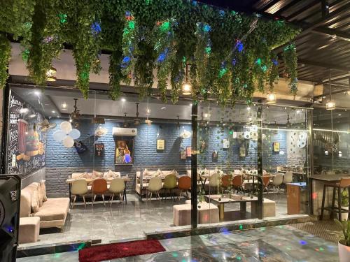 - un restaurant avec des tables et des chaises dans une salle dans l'établissement Hotel Fortune Ganga, à Haridwar