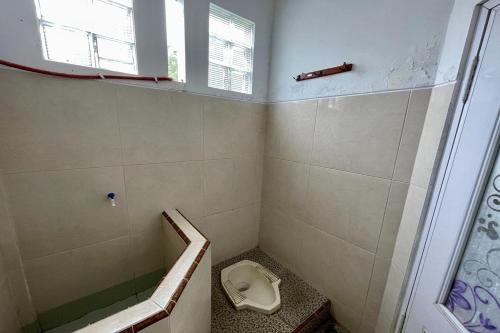 a small bathroom with a toilet and a shower at Rizky Bromo Homestay in Lambangkuning