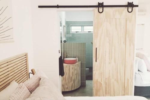 a bathroom with a shower with a wooden door at Stylish family unit in Walmer in Gqeberha