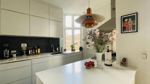 a kitchen with a table with a vase of fruit on it at ApartmentInCopenhagen Apartment 1590 in Copenhagen