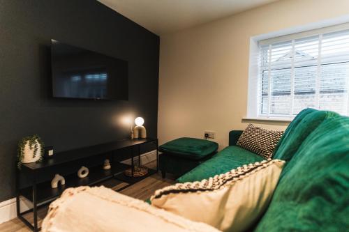 a living room with a green couch and a window at Feature Stone, Stunning Apartment, 2 x King Beds and Single, Sleeps 5 in Castle Cary