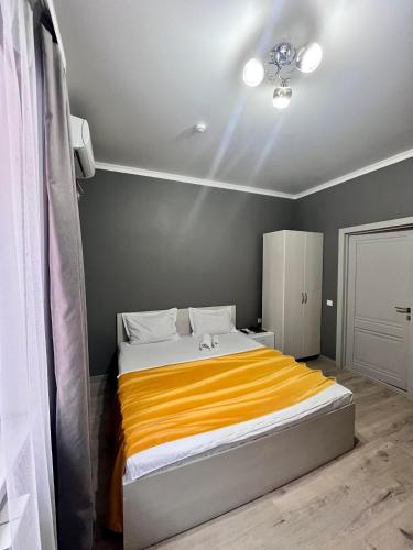 1 dormitorio con 1 cama con manta naranja en Мини-гостиница Береке en Aktobe