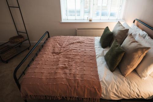 a bedroom with a bed with pillows and a window at Feature Stone, Stunning Apartment, 2 x King Beds and Single, Sleeps 5 in Castle Cary