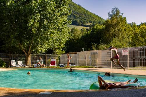 un groupe de personnes dans une piscine dans l'établissement Camping Saint-Lambert - Maeva, à Millau