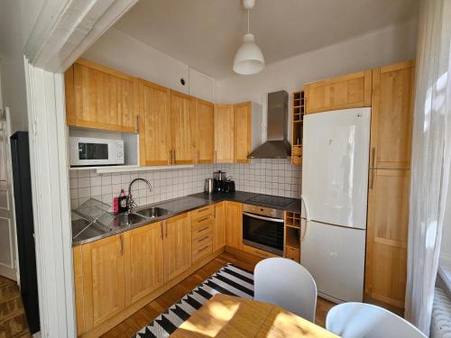 een keuken met houten kasten en een witte koelkast bij Home Inn KG26 in Stockholm