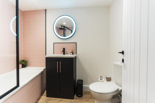 een badkamer met een toilet, een wastafel en een spiegel bij Feature Stone, Stunning Apartment, 2 x King Beds and Single, Sleeps 5 in Castle Cary