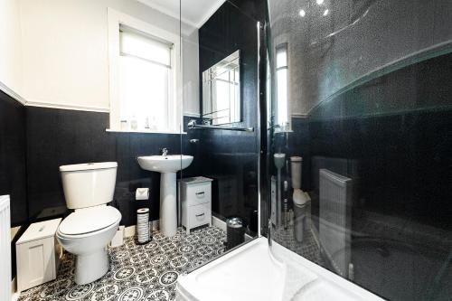 a black and white bathroom with a toilet and a sink at An Caladh in Balallan