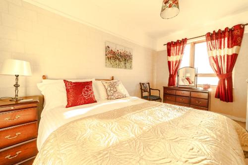 sypialnia z dużym łóżkiem z czerwonymi poduszkami w obiekcie An Caladh w mieście Balallan
