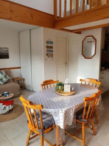 - une table à manger et des chaises dans le salon dans l'établissement O ABRIGO Maison avec Piscine proche Mer/ Plage, à La Tranche-sur-Mer