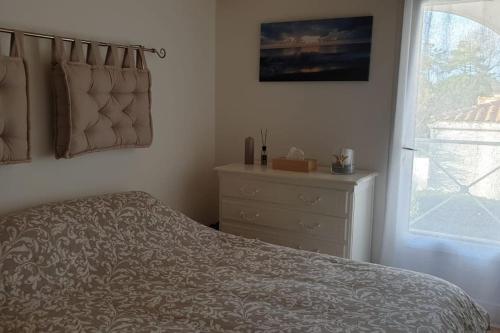 une chambre avec un lit, une commode et une fenêtre dans l'établissement O ABRIGO Maison avec Piscine proche Mer/ Plage, à La Tranche-sur-Mer