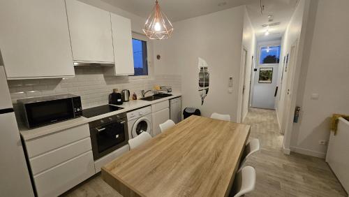 une cuisine avec une table en bois et une salle à manger dans l'établissement Renardière, à Montreuil