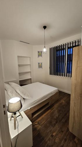 une chambre blanche avec un lit et une chaise dans l'établissement Renardière, à Montreuil