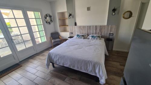 1 dormitorio con 1 cama grande con sábanas y almohadas blancas en Gîtes de 2 à 11 personnes au Domaine d'USSON, en Échebrune