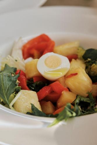 a bowl of food with an egg on top of vegetables at Prinsotel Mal Pas - Adults Only in Alcudia