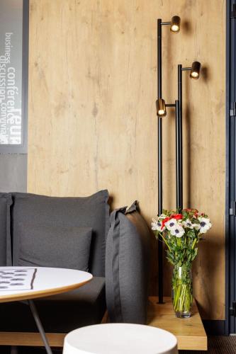 a living room with a table and a vase of flowers at ibis Valence Sud in Valence