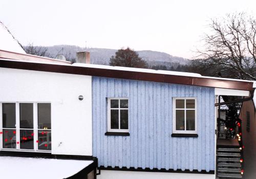 a blue and white house with snow on the ground at Ferienwohnungen Fischer in Strullendorf