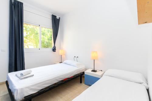 - 2 lits dans une chambre avec fenêtre dans l'établissement Villa Serena, à Lloret de Mar