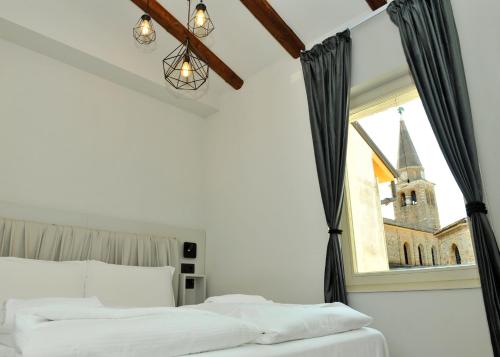 ein Schlafzimmer mit einem Bett und ein Fenster mit einer Kirche in der Unterkunft Ca’ Bruno Masaneta in Grado