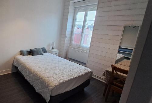 ein kleines Schlafzimmer mit einem Bett und einem Fenster in der Unterkunft HOTEL DE FRANCE in Éguzon-Chantôme