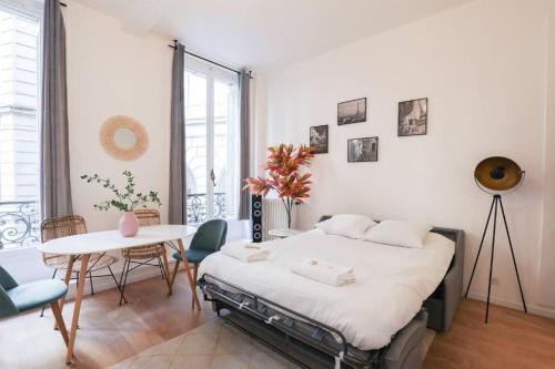 Schlafzimmer mit einem Bett, einem Tisch und Stühlen in der Unterkunft Splendide appartement proche Opéra Garnier - 6P in Paris