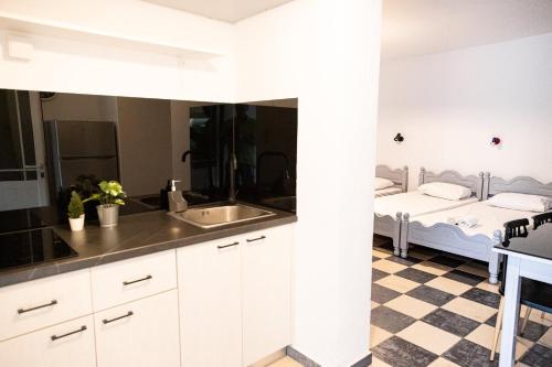 a kitchen with a sink and a bed in a room at Koala Place in Vasiliki