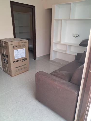 a cardboard box and a couch in a room at Srinivasa Nilayam in Hyderabad