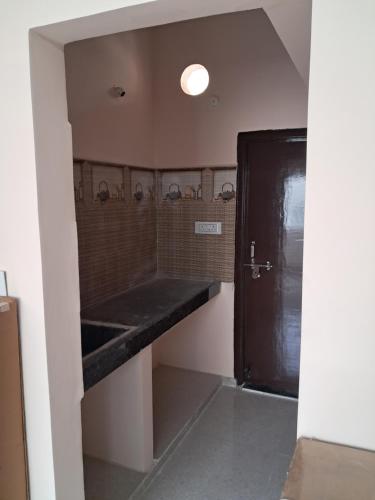 a bathroom with a black counter and a black door at Srinivasa Nilayam in Hyderabad