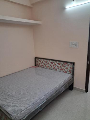 a small bedroom with a bed in the corner at Srinivasa Nilayam in Hyderabad