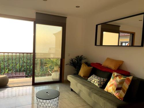 a living room with a couch and a mirror at Apartamento Los Guirres in Tazacorte